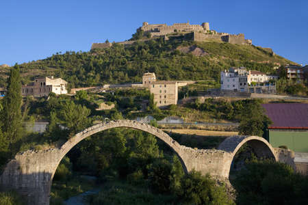 Ancient stone arch bridges with a background of Parador de Cardona, a 9th Century medieval hillside Castle, near Barcelona, Catalonia, Cardona, Spainのeditorial素材