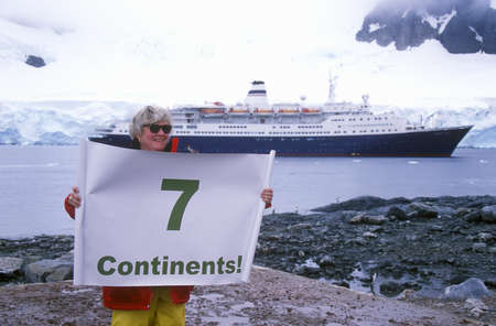 Ecological tourist from cruise ship Marco Polo with Seven Continents sign at Paradise Harbor, Antarcticaのeditorial素材