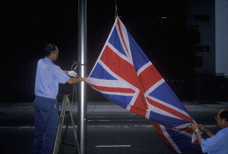 Man lowering British Union Jack flag in Hong Kongのeditorial素材