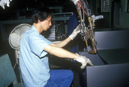 Factory workers at Shanghai Shangling Electric Appliances Company, Ltd., in Shanghai, People's Republic of Chinaのeditorial素材