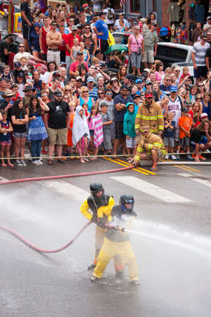 Men dressed in yellow firemen slickers and firehoses have annual Waterfight on July 4, Main Street, Ouray, CO, sponsored by Ouray Fire Departmentのeditorial素材