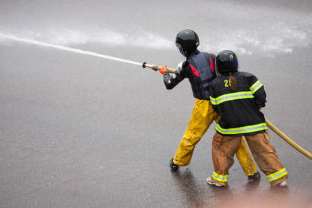Men dressed in yellow firemen slickers and firehoses have annual Waterfight on July 4, Main Street, Ouray, CO, sponsored by Ouray Fire Departmentのeditorial素材