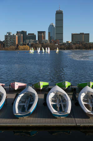 Colorful docked sailboats and Boston Skyline in winter on half frozen Charles River, Massachusetts, USAの写真素材