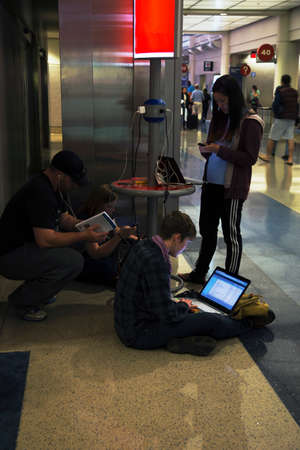 Airport travelers charging their battaries for computers, ipad and cell phones, airport