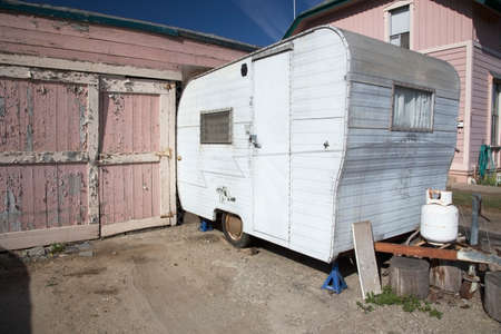 White beatup trailer parked in front of pink garage, Ventura, California, USA