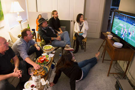 Group of people watch NFL Superbowl XLVIII on television, Feb. 2, 2014, Denver Broncos vs. Seattle...