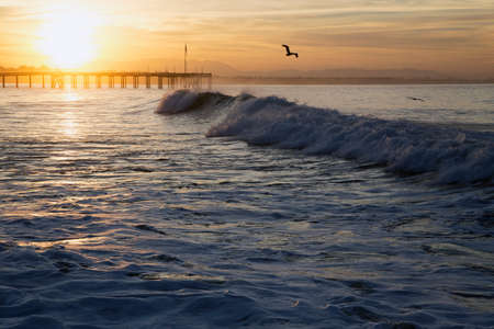 Ocean waves at sunrise with Ventura Pier, Ventura, California, USAの写真素材