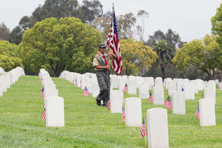 Boyscout places one of 85, 000 US Flags at 2014 Memorial Day Event, Los Angeles National Cemetery, California, USAのeditorial素材