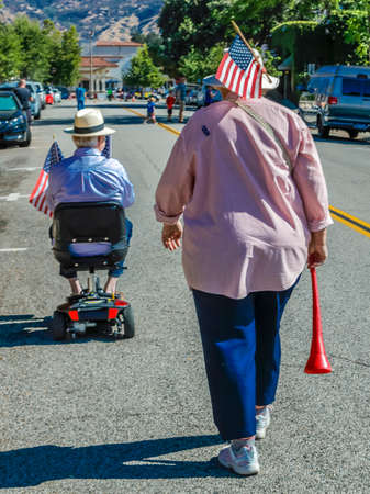 - woman and man in wheel chair are walking from paradeのeditorial素材