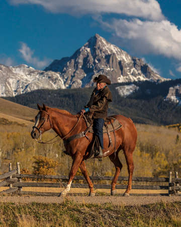OCT 4, 2017, RIDGWAY COLORADO - Older Cowboy, Howard Linscott , leads packhorse across historic Last Dollar Ranch on Hastings Mesa, SW Colorado, San Juan Mountainsのeditorial素材