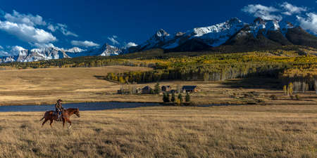 OCT 4, 2017, RIDGWAY COLORADO - Older Cowboy, Howard Linscott , leads packhorse across historic Last Dollar Ranch on Hastings Mesa, SW Colorado, San Juan Mountainsのeditorial素材