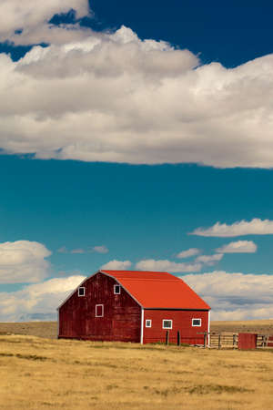 OCTOBER 10, 2018 - Oklahoma, USA Red barn in field with puffy clouds in remote Oklahomaのeditorial素材