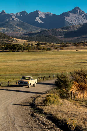 September 28,, 2018, USA - Pickup truck drives County Road 24 near Ridgway Colorado looking towards San Juan Mountainsのeditorial素材