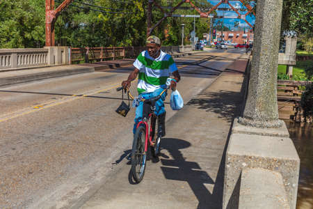 October 14, 2018 - African American on bike crosses Breau Bridge, Louisiana, USA - Welcome to Breau Bridge, Louisiana, Crab fishing townのeditorial素材