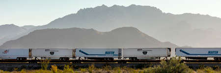 SEPT 13, 2013 - CALIFORNIA, USA - Freight train carries truck trailers under mountain near Needles California in American Southwestのeditorial素材