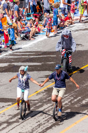 TELLURIDE, COLORADO, USA - July 4, 2018 - Annual  Independence Day Parade, Telluride, Colorado Colorado Avenue shows couple holding hands on Unicyclesのeditorial素材