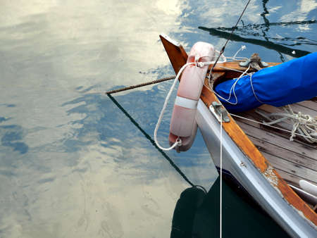 bow of boat anchored with life buoy