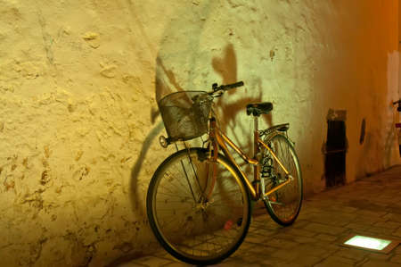 The bicycle standing at a wall.Residentes of Citadella on the island Menorca prefer to move by bicycles. In the evening in this part of the island it is possible will meet a huge number of various bicyclesの写真素材