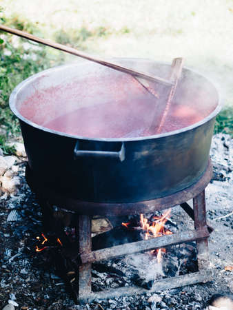 Traditional cuisine big black pot cooking food, natural fire with wood heatingの写真素材