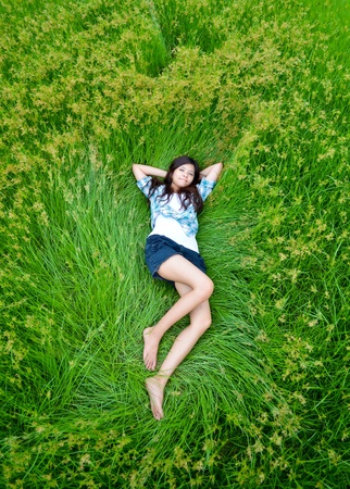 this girl is lying on the meadow and chilling out with her lifeの写真素材