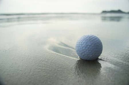 a white golf ball on the beach