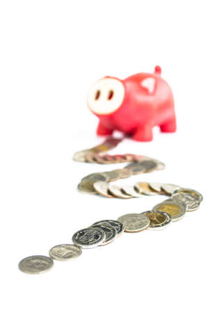 red piggy stand against pile of coin on white backgroundの写真素材