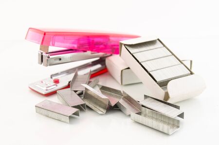 pink stapler with pile of needle on white background