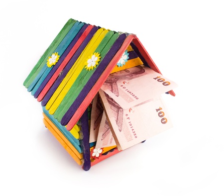 colorful toy house with money isolatd on white backgroundの写真素材