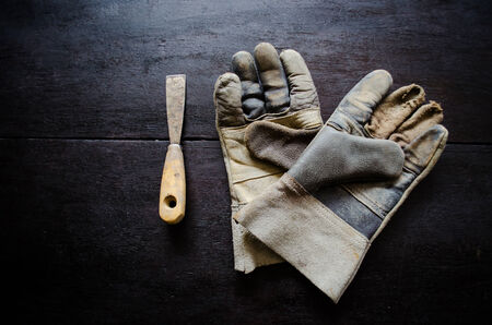 old leather gloves and rusty trowel on wooden tableの写真素材