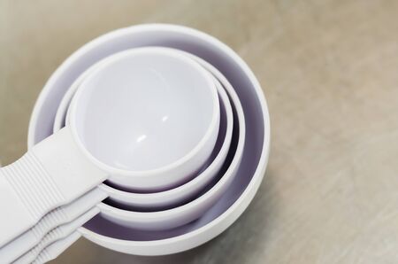 close up of white plastic measuring spoon on wood backgroundの写真素材