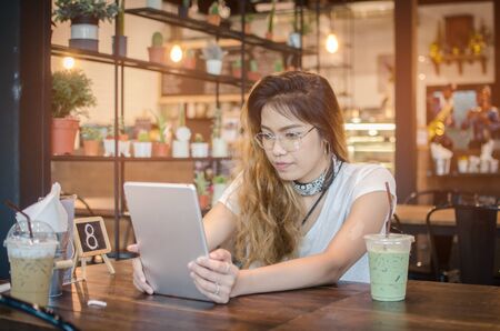 girl using tablet on wooden tableの写真素材