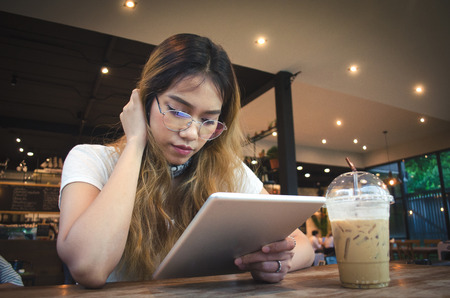 girl using tablet on wooden tableの写真素材