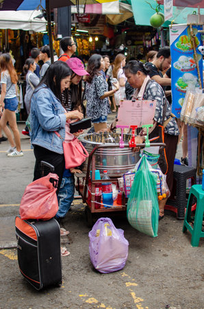 CHATUCHAK, BANGKOK, THAILAND, NOV 19, 2017 : tourist buying tube thai popsicle at Chatuchak Weekend Market, November 2017のeditorial素材