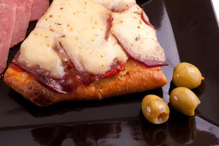 A Slice of supreme pizza being lifted up with olive の写真素材