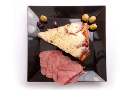 A Slice of supreme pizza being lifted up with olive の写真素材