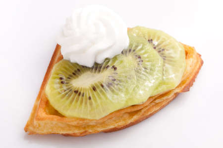 Kiwi Tart Slices with fresh vanilla cream on white dishの写真素材