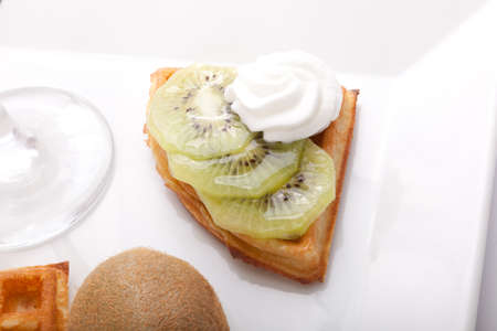 Kiwi Tart Slices with fresh vanilla cream on white dishの写真素材