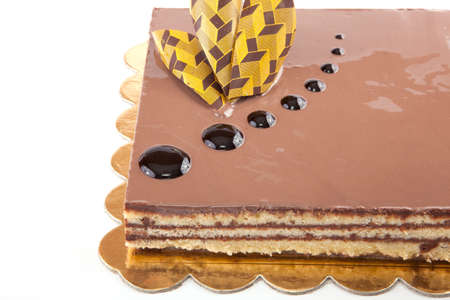 Chocolate glossy light cake on white stuffed with nuts