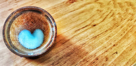salt hodgepodge in the form of a heart on a wooden tableの写真素材
