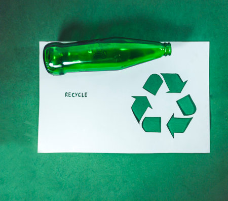 recycle symbol on a white paper with green bottle on green backgroundの写真素材
