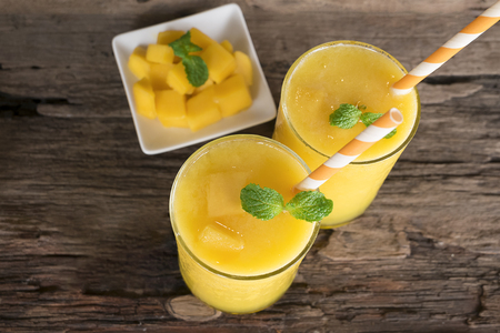 Mango smoothies, fruit juices and mango fruits from wood background, drink to lose weight.の写真素材
