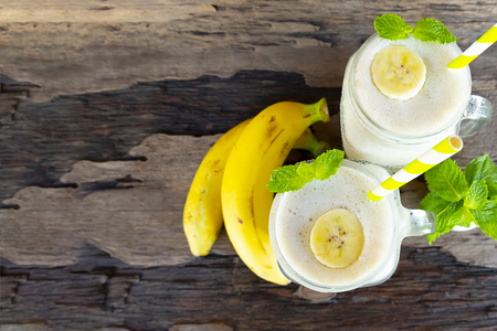 Banana fresh cocktail vanilla smoothies  fruit juice beverage healthy the taste yummy  in glass drink episode good morning on wooden background from top view.の写真素材