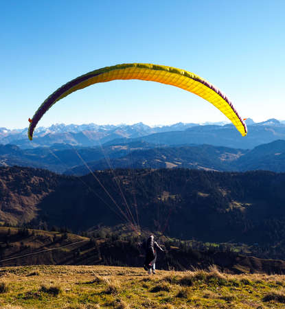Paraglider in the Bavarian Alpes in front of mountain panorama and blue skyの写真素材
