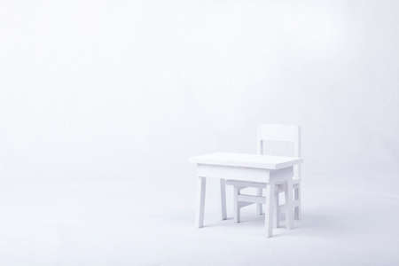 White wooden chair and desk over white background. Copy space.の写真素材
