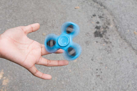 Kid plays with fidget spinner stress relieving toyの写真素材