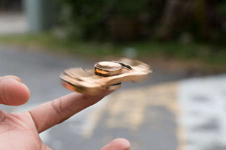 Kid plays with fidget spinner stress relieving toyの写真素材