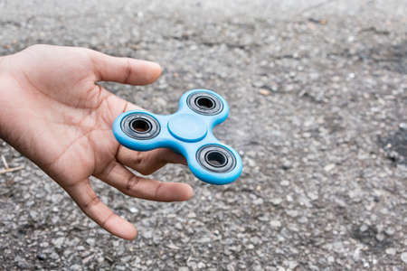 Kid plays with fidget spinner stress relieving toyの写真素材