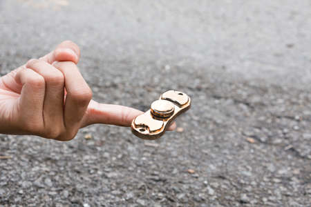 Kid plays with fidget spinner stress relieving toyの写真素材