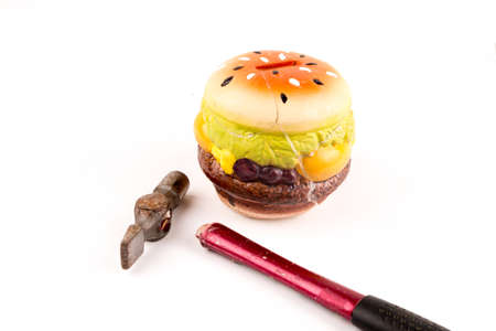 Broken hammer with intact piggy bank isolated on a white backgroundの写真素材