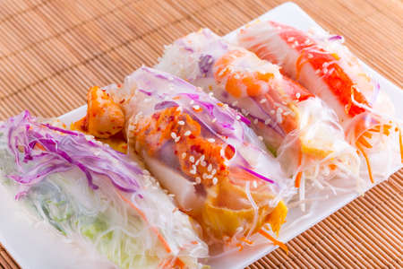 Vietnamese spring-roll on a white plate on a mat backgroundの写真素材